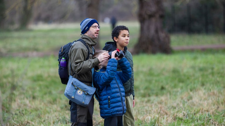 Visitors watch for birds through binoculars at Morden Hall Park, London